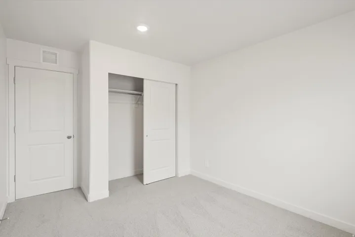 Neutral-toned room with light gray carpeting and white walls