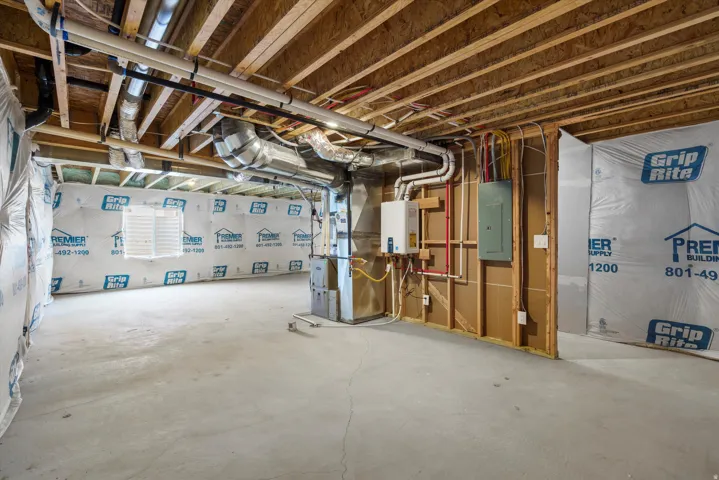 Unfinished basement with exposed ceiling joists and concrete flooring