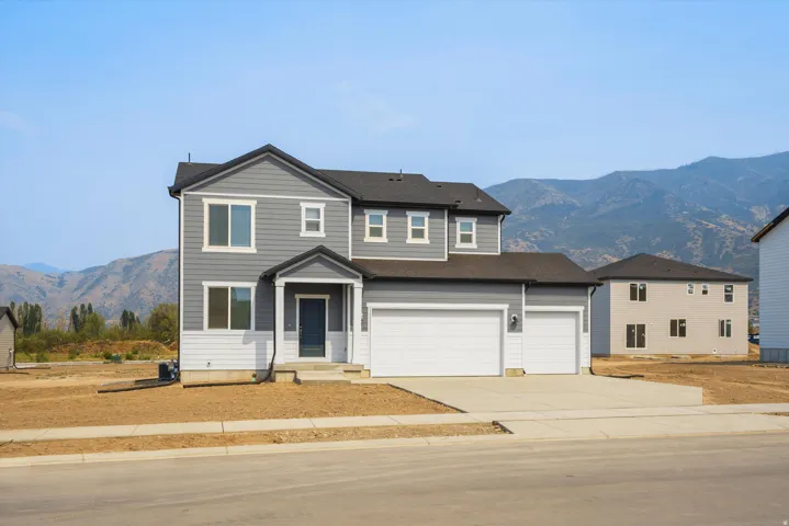 **DISCLAIMER** Elevation may vary. Two-story residence featuring gray siding with white trim, a dark asphalt shingle roof, and a two-car garage with white doors
