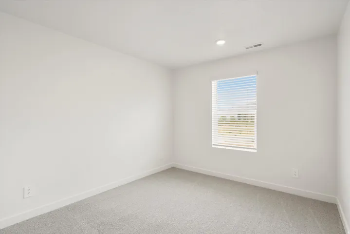 Bright room with neutral wall paint and light gray carpet flooring