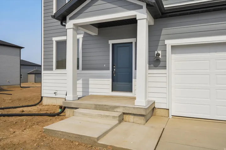 **DISCLAIMER** Elevation may vary. nviting entry featuring a covered porch, concrete steps, and a bold blue door