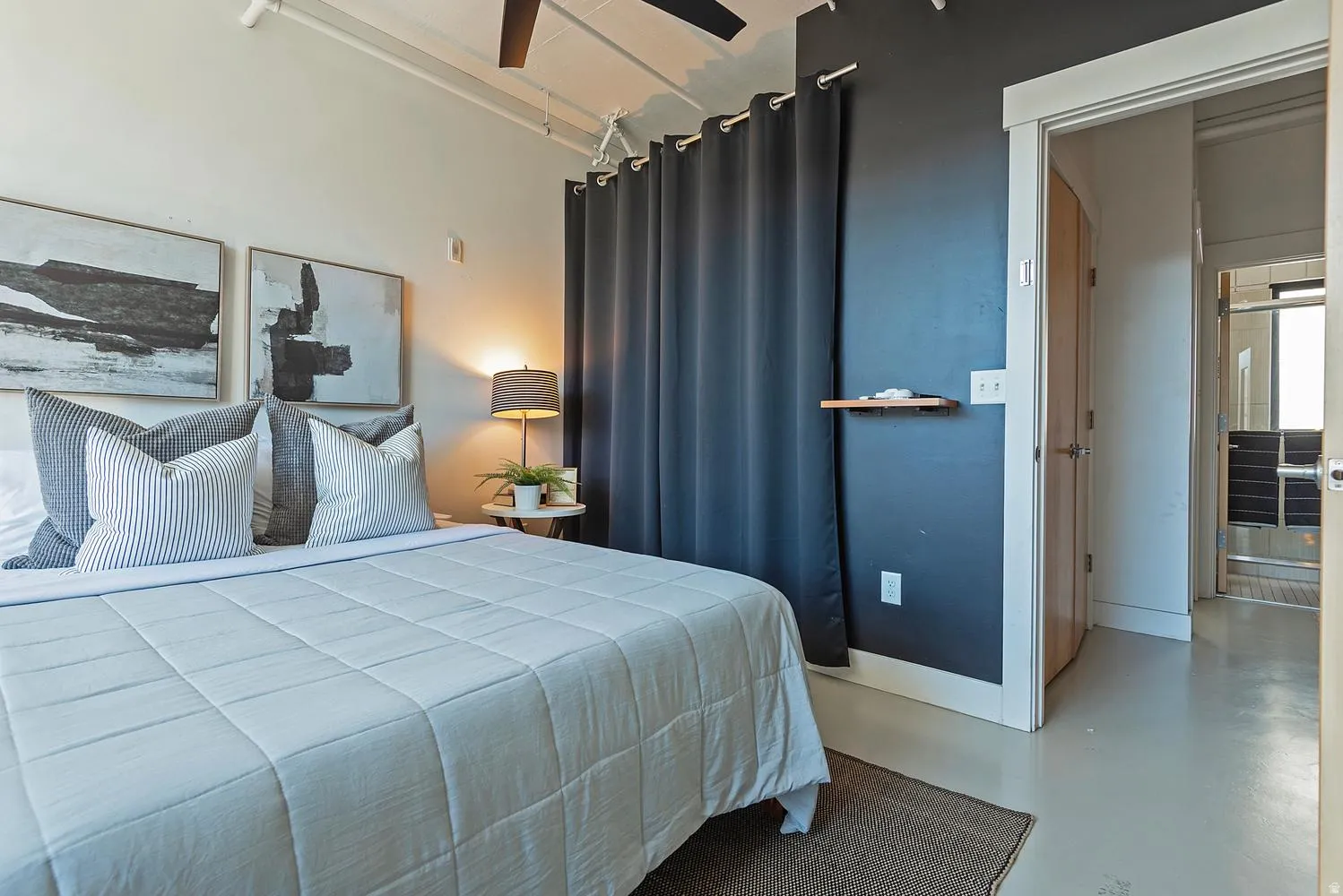 Bedroom featuring a high ceiling with exposed conduit, a ceiling fan, and light-toned flooring