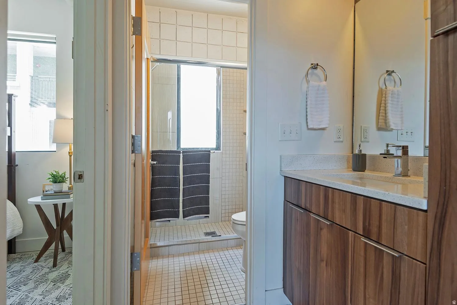 Bathroom vanity featuring wood-finish cabinetry, a light-toned countertop, and a built-in sink with a chrome faucet