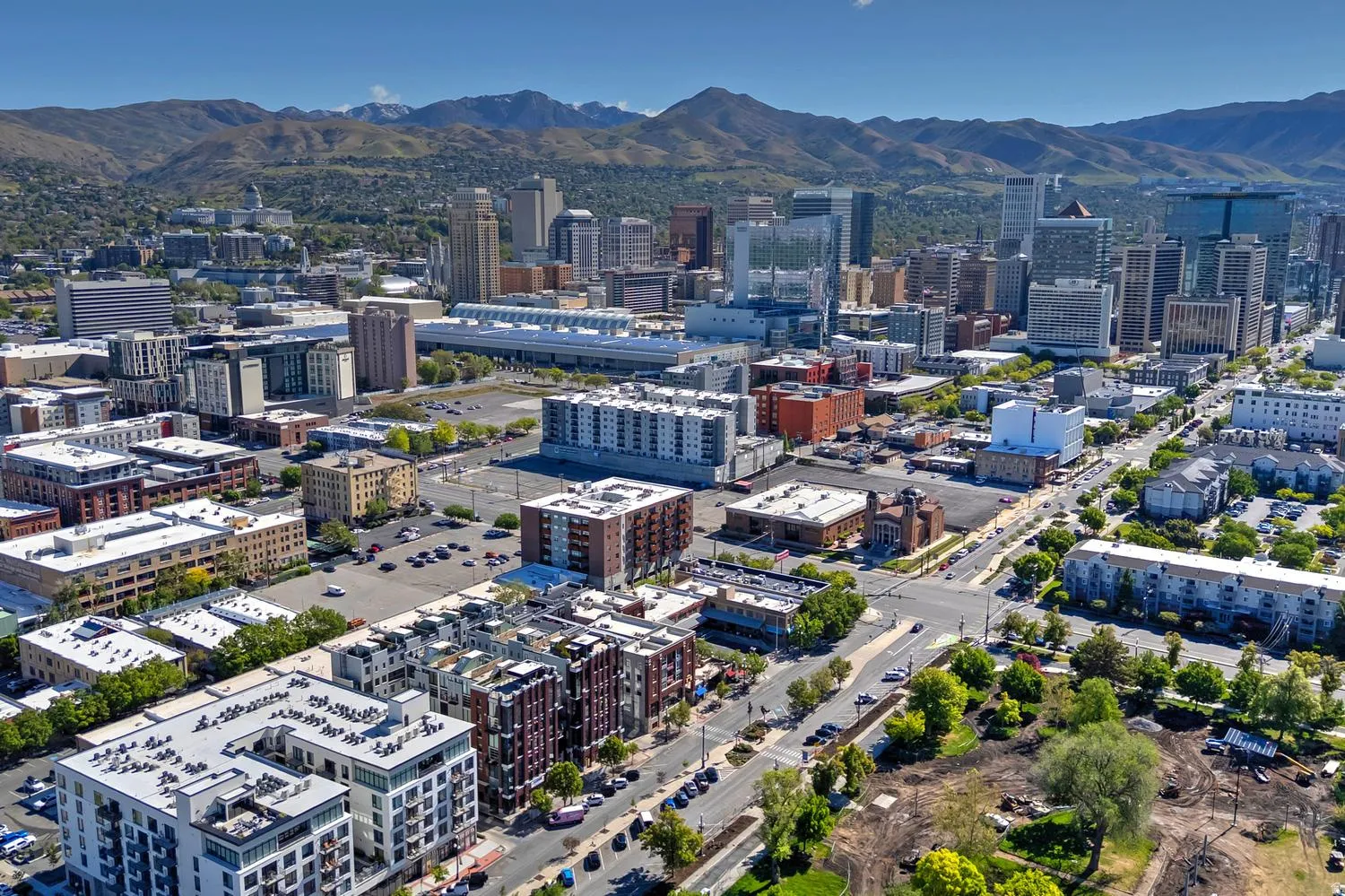 Aerial perspective showcasing a vibrant urban landscape with a backdrop of distant mountains