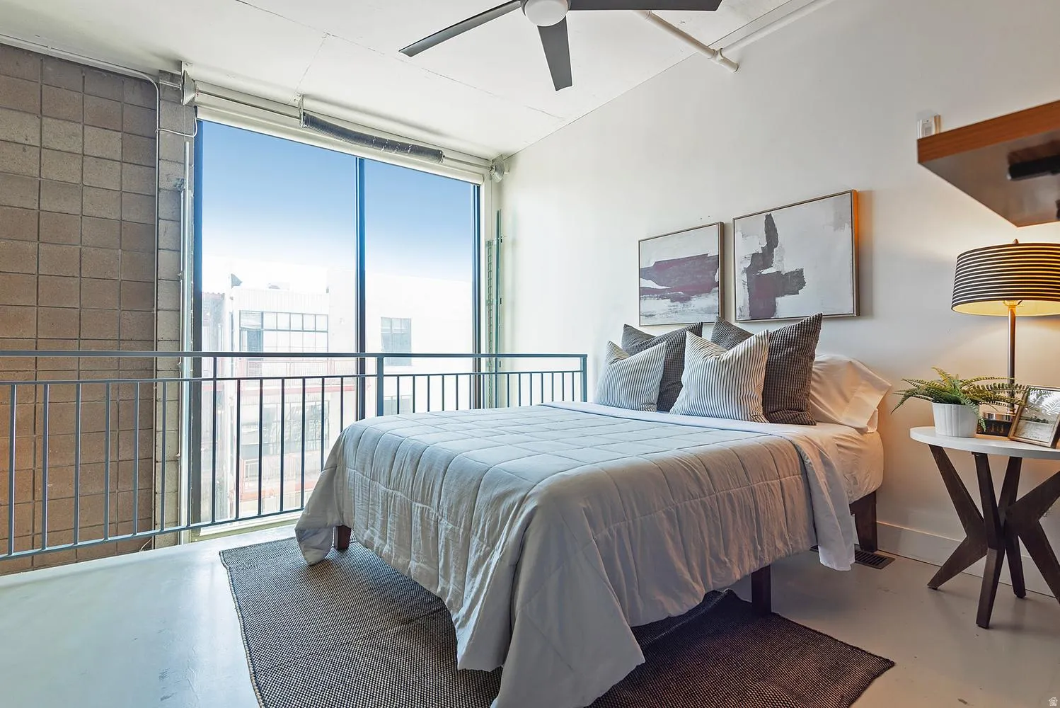 Expansive floor-to-ceiling windows with a metal railing