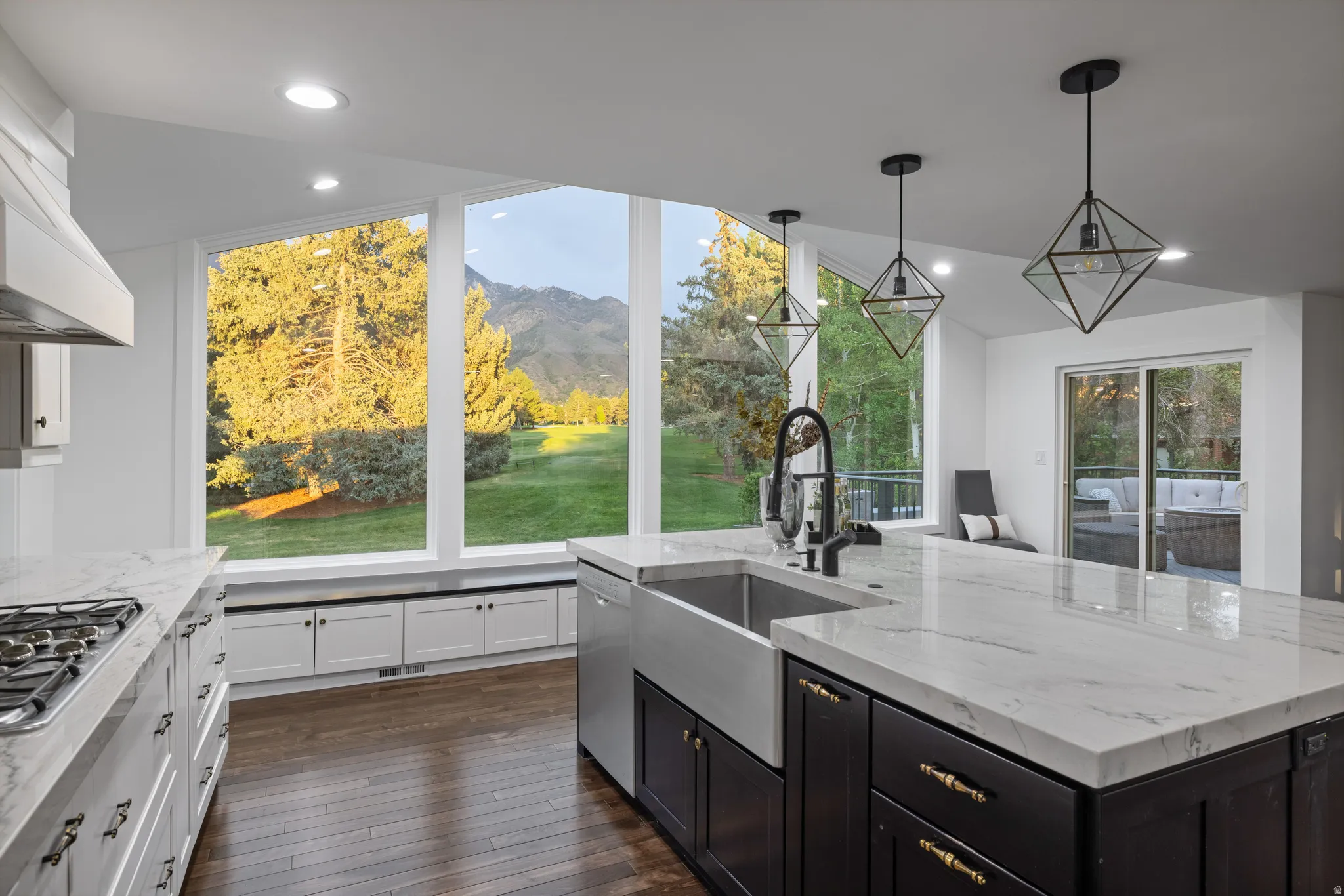 Kitchen featuring a large central island with a farmhouse sink, stainless steel appliances, and light-toned countertops