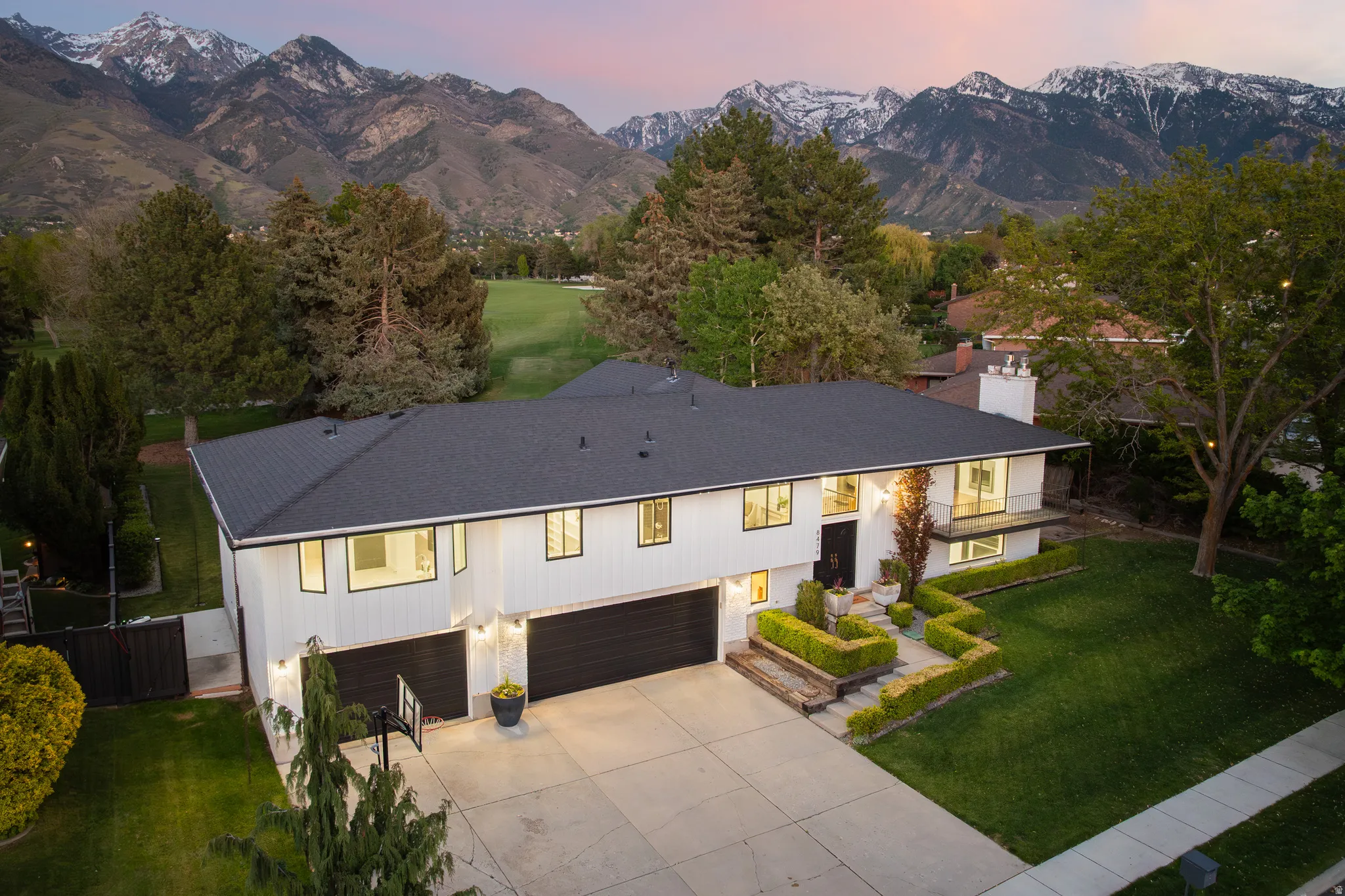 Modern white exterior with dark trim and a black shingle roof
