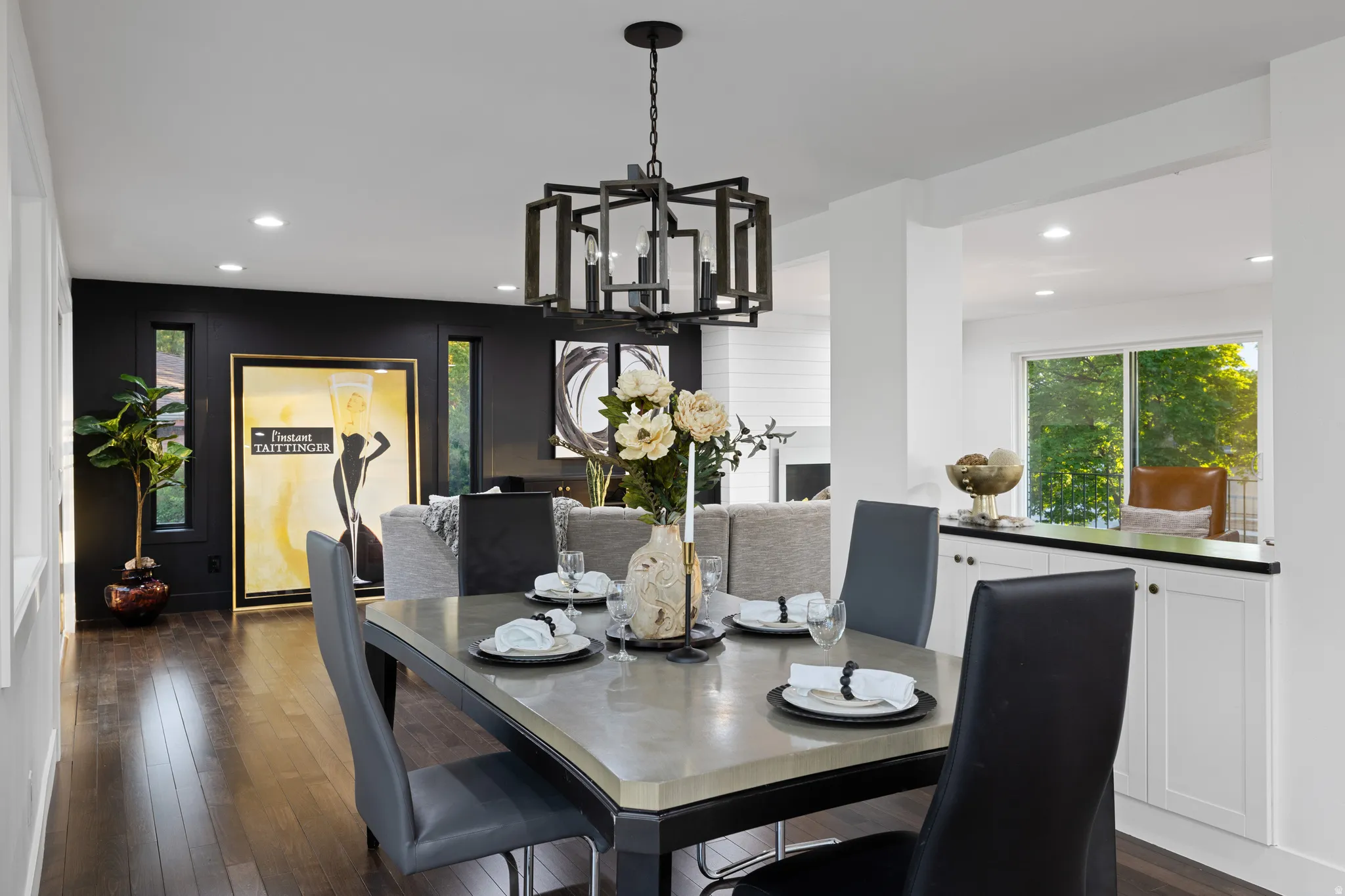 Open concept dining area featuring a modern chandelier, dark wood-finish flooring, and recessed lighting
