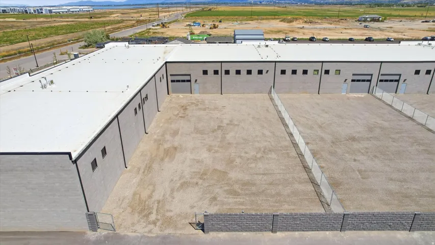 Industrial building featuring multiple bay doors and a large open lot area