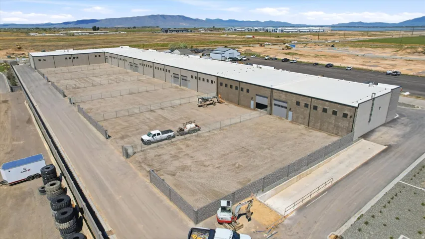 Industrial building featuring a light-colored flat roof, multiple bay doors, and a block exterior