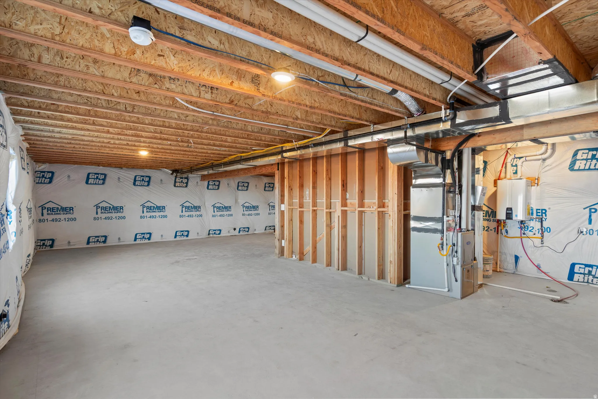 Unfinished basement space featuring exposed wood joists and concrete flooring