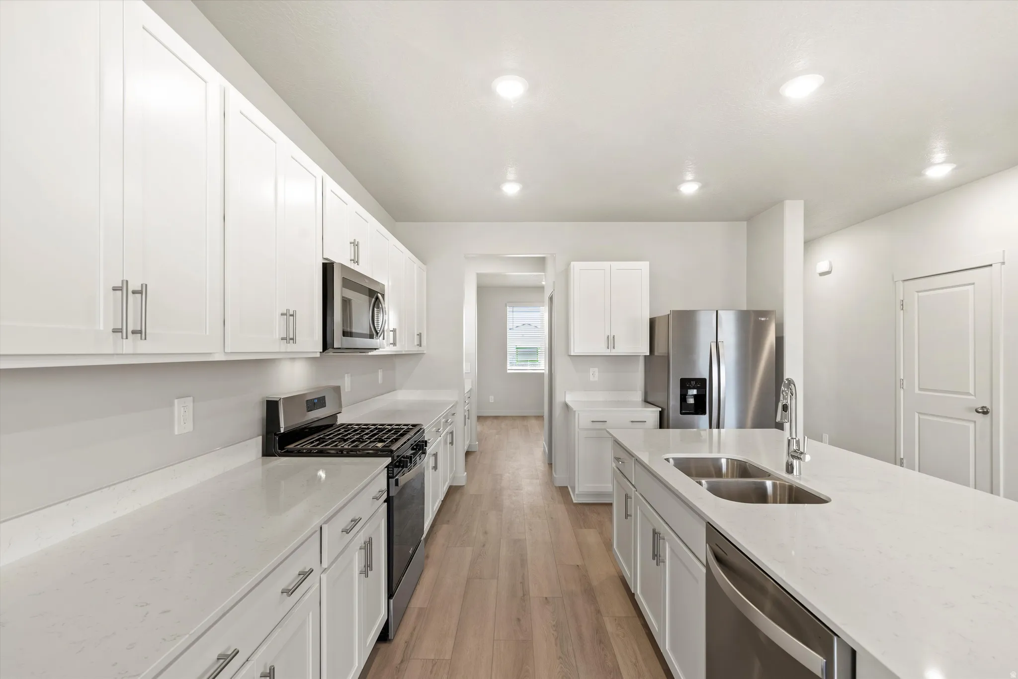 Modern kitchen featuring an expansive center island with an undermount double sink and dishwasher