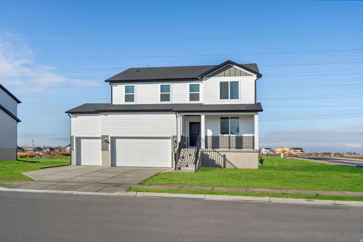 Contemporary two-story residence featuring a white siding exterior with dark trim accents