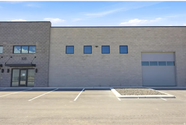 Commercial building with a gray brick facade and a roll-up garage door
