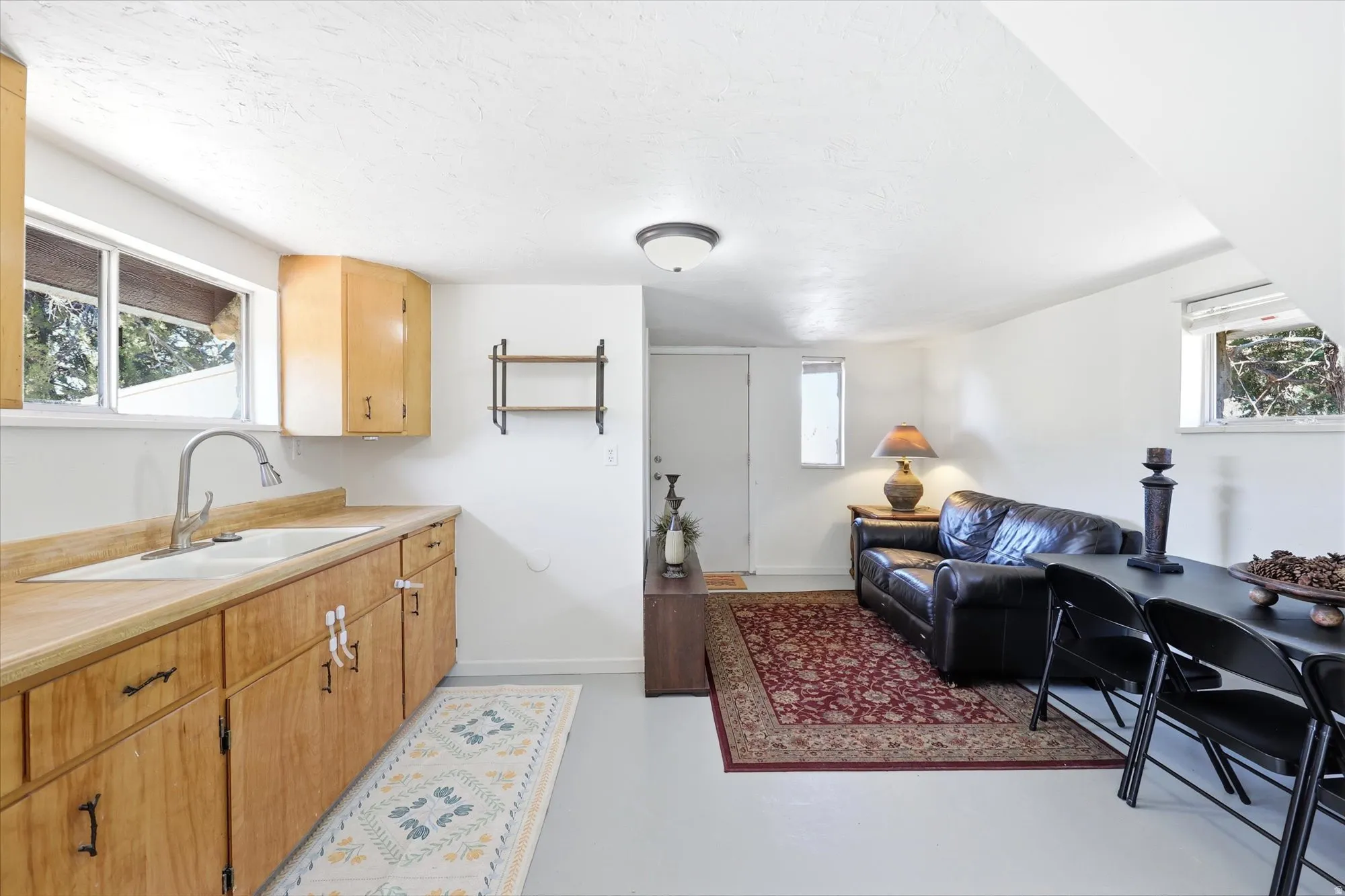 Kitchen with light countertops, open floor plan, and finished concrete flooring