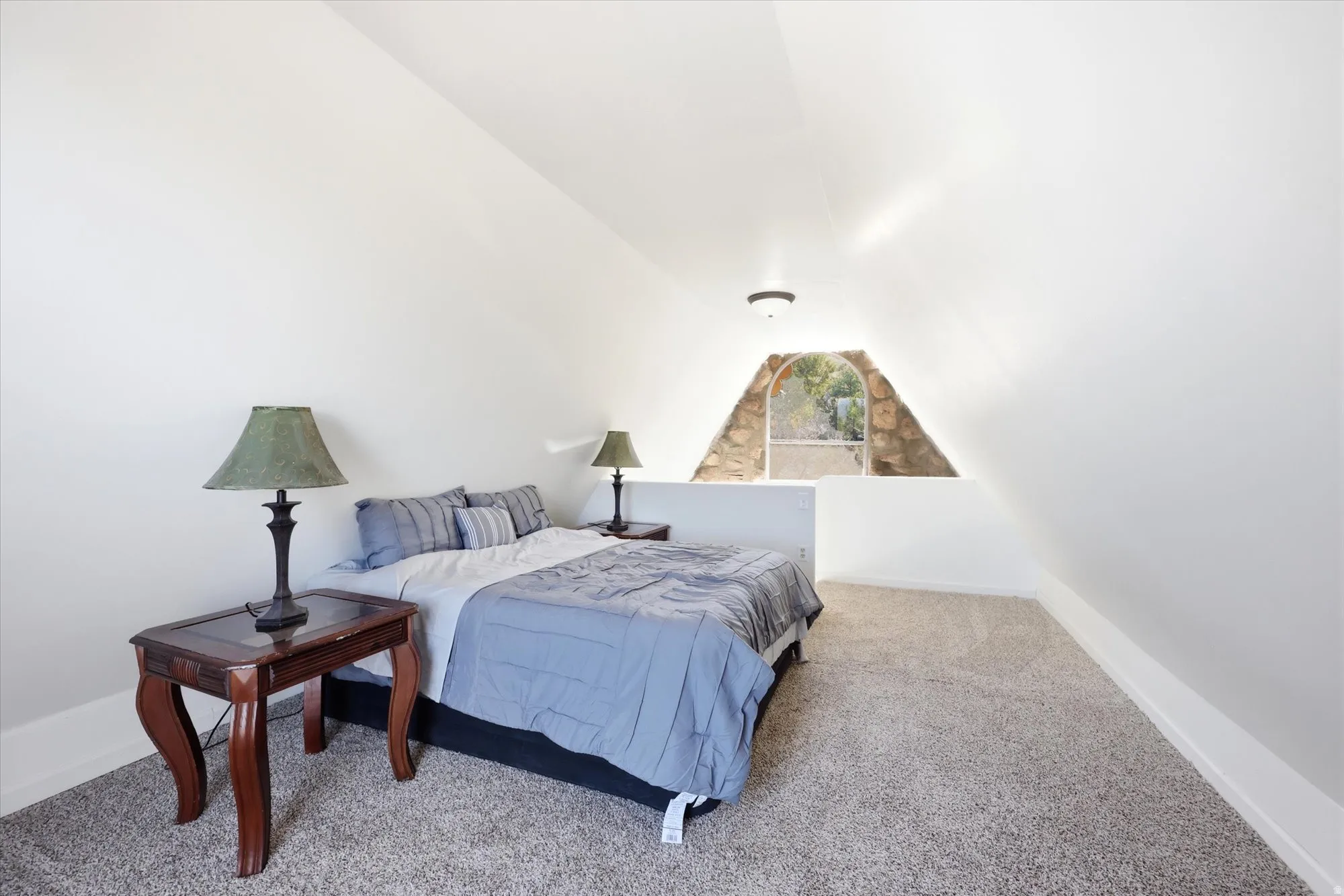 Bedroom with light colored carpet and baseboards