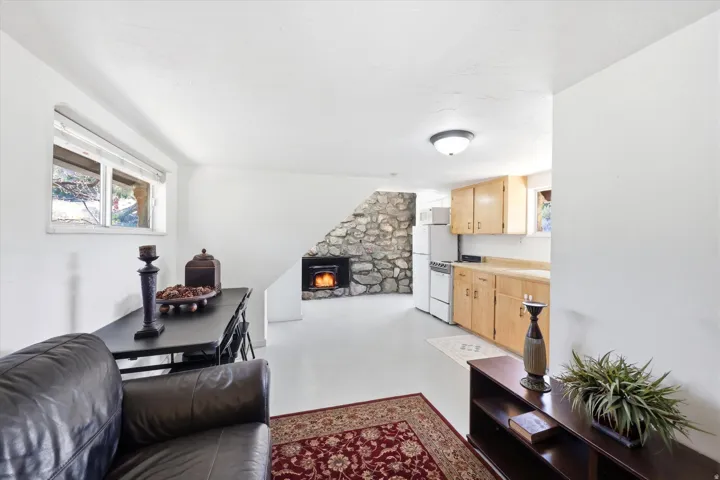 Living area featuring concrete floors, healthy amount of natural light, and a stone fireplace