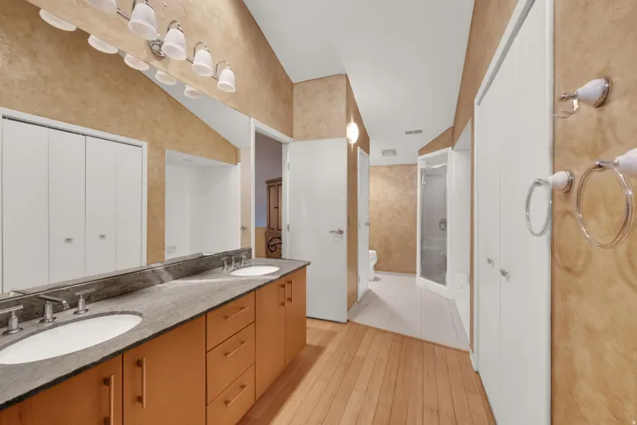 Double vanity with integrated sinks and brushed nickel faucets, set atop a stone countertop and wood-finish cabinetry