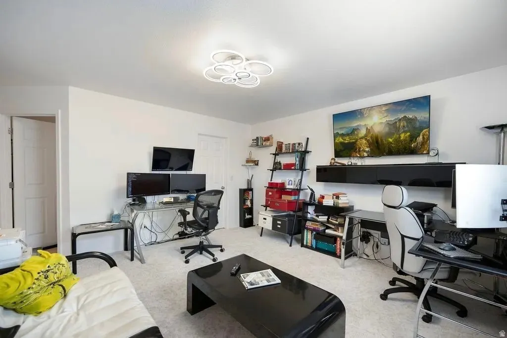 Spacious room with white walls and light-colored carpeting