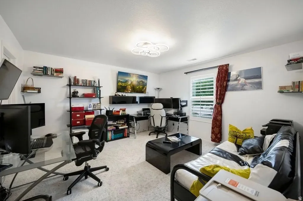 Carpeted room featuring a modern ceiling light fixture and white walls