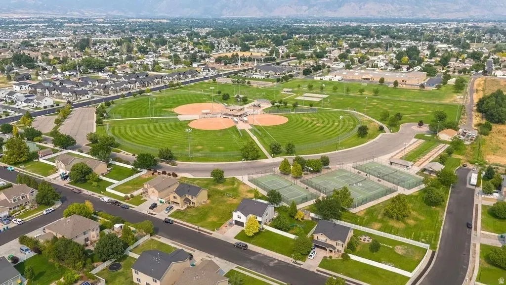 Expansive community park featuring multiple baseball diamonds with manicured outfields, several tennis courts, and recreational green spaces