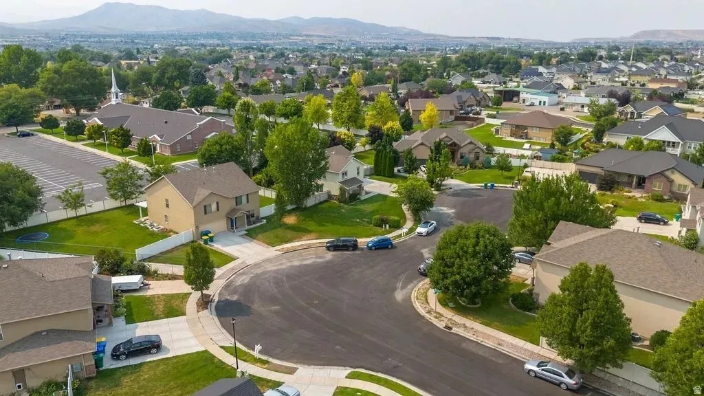 Residential neighborhood featuring varied architectural styles, mature trees, and a mountain backdrop