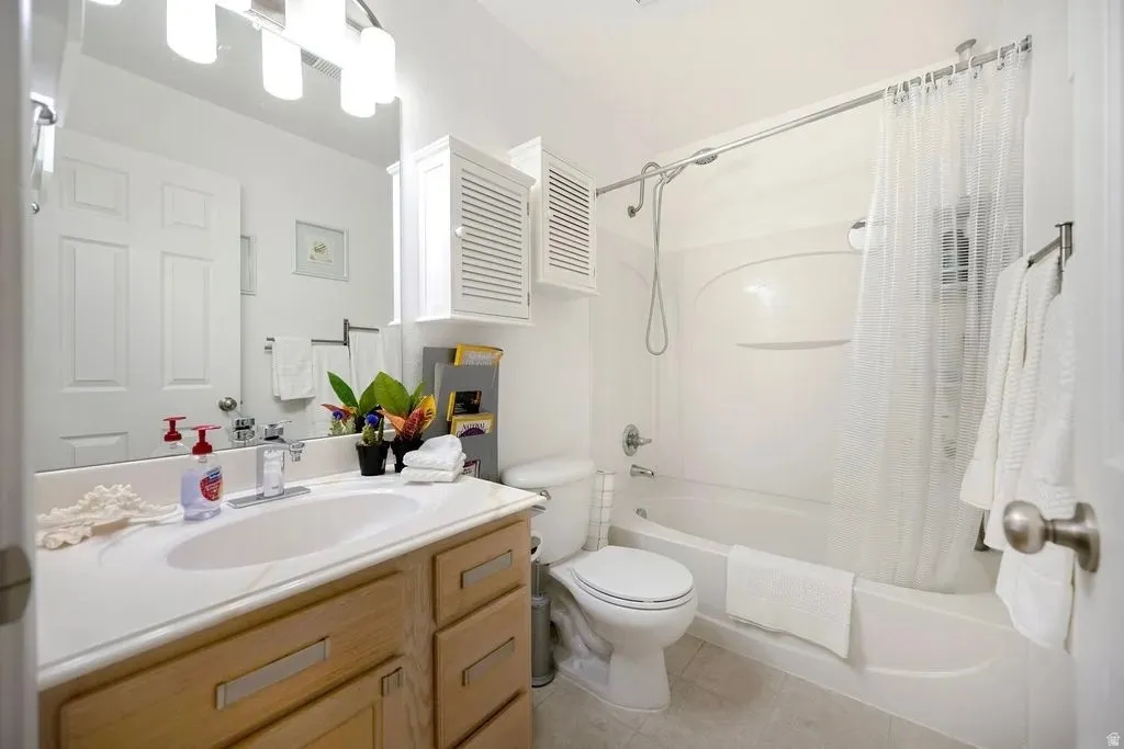Bathroom featuring a built-in bathtub and shower combination, a wood-finish vanity with an integrated sink, a large mirror, and recessed storage cabinetry