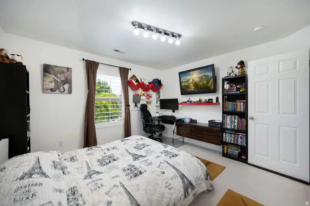 Bright room featuring a single window with white horizontal blinds, a six-panel white door, and recessed ceiling lighting