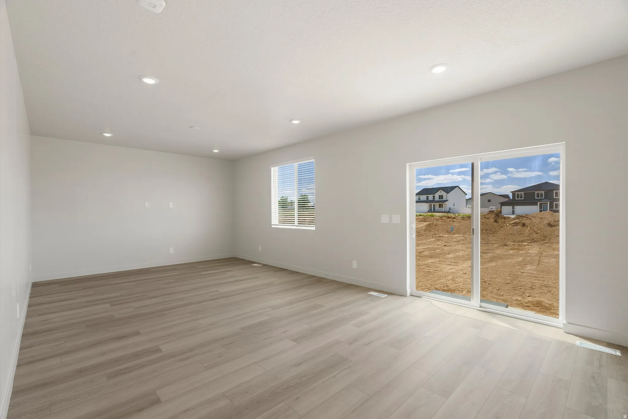 Bright interior space featuring light wood-finish flooring, recessed lighting, and neutral wall paint