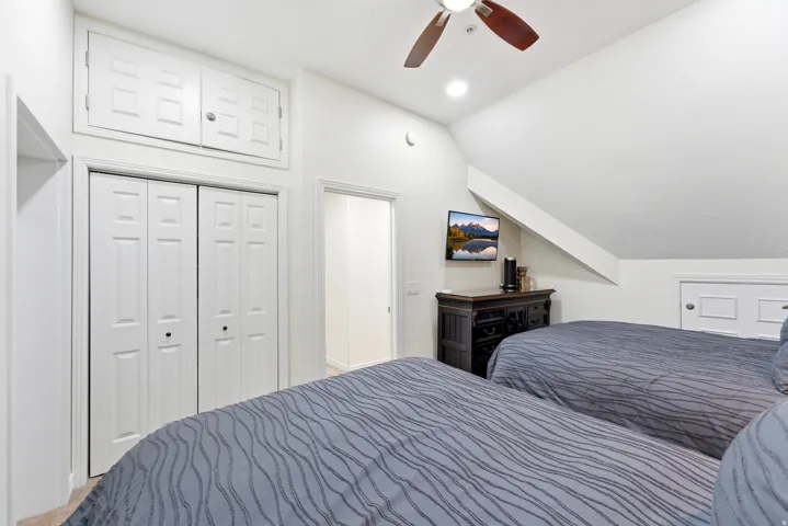 Bedroom with lofted ceiling, a ceiling fan, a closet, and recessed lighting
