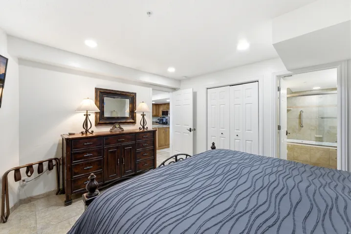 Bedroom with a closet, ensuite bathroom, recessed lighting, and light tile patterned flooring