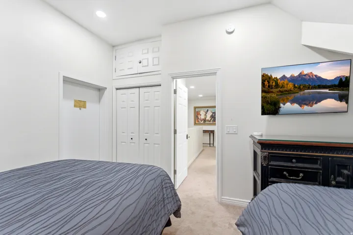 Bedroom with light carpet, a closet, and recessed lighting