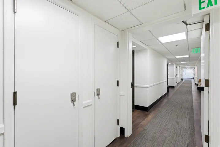 Corridor with a paneled ceiling and dark wood-style flooring