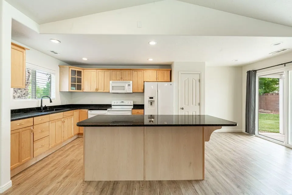 Kitchen featuring light wood cabinetry and a central island with a dark countertop