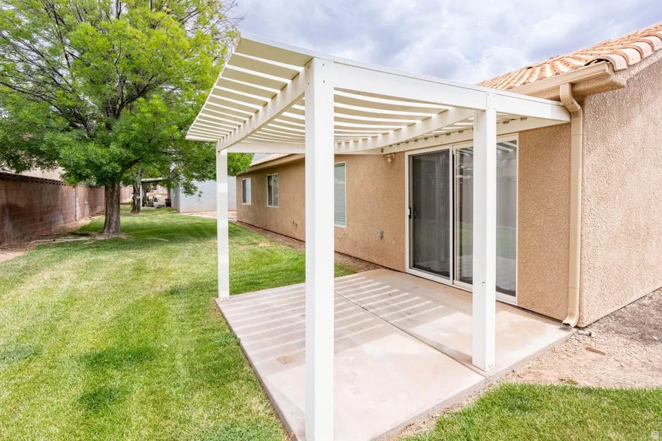 Covered patio space featuring a concrete slab and a white slatted pergola