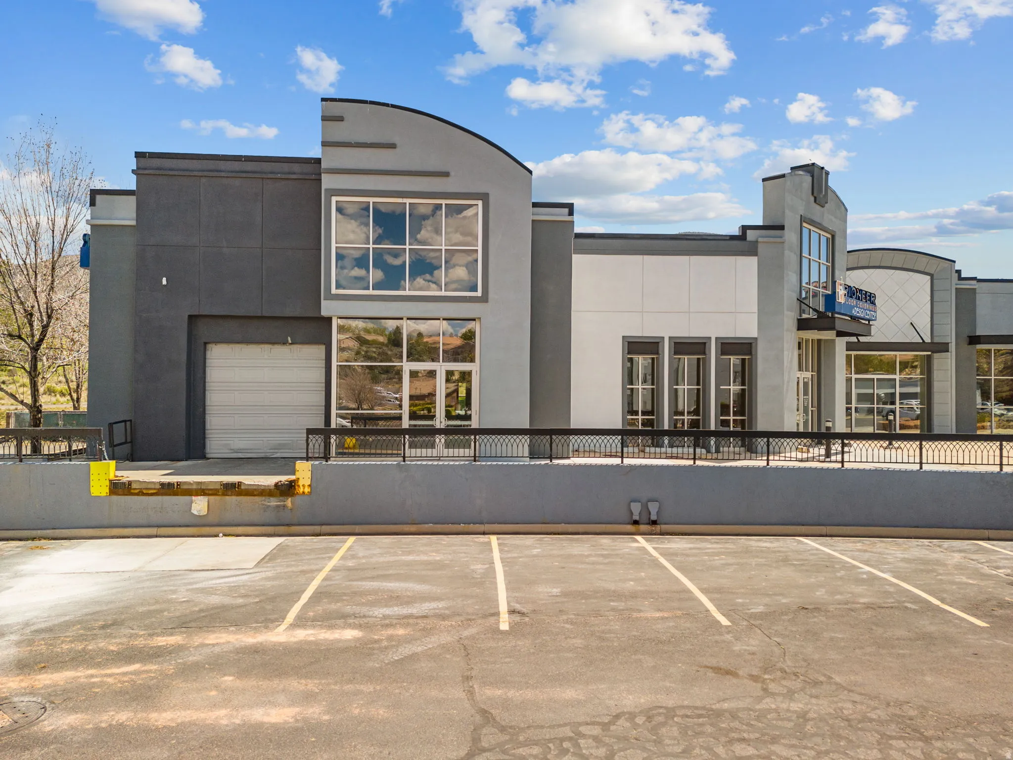 Contemporary commercial building featuring a multi-tone gray facade with arched and linear architectural details