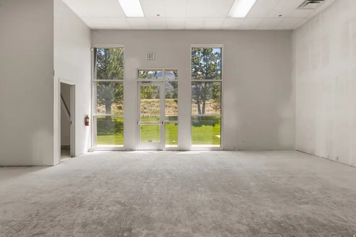 Spacious room featuring multiple large windows and a glass-paneled entry door, providing abundant natural light