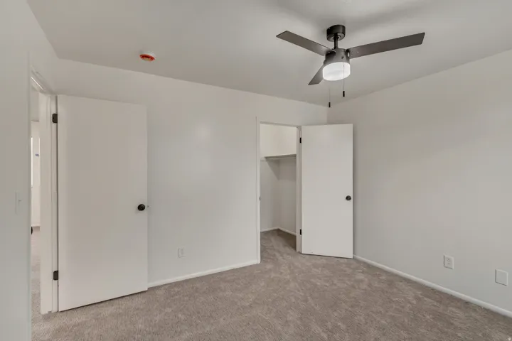 Neutral wall finishes, recessed lighting, and a ceiling fan with integrated illumination