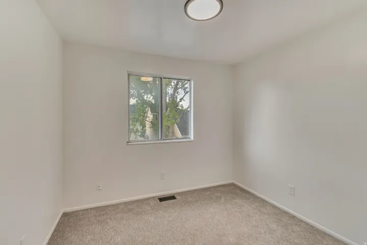 Neutral tone wall paint with carpeting and a window