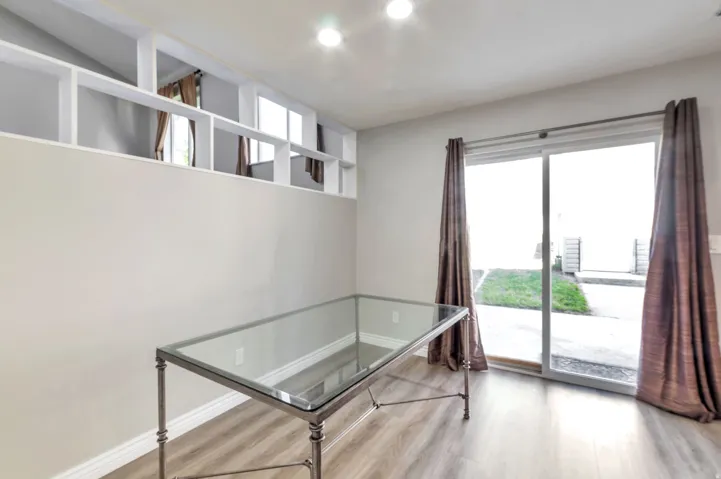 Interior space featuring wood-finish flooring, a full wall with integrated shelving, and recessed lighting