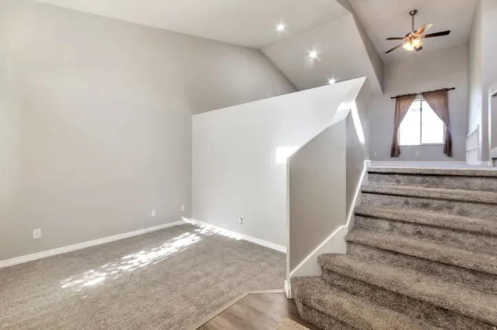 Carpeted staircase with white balustrade leading to an upper level