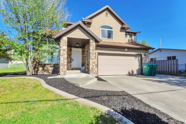 Two-story exterior with light beige siding and stone facade accents