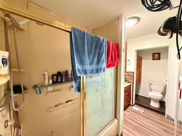 Shower enclosure with gold-finish trim and a frosted glass door