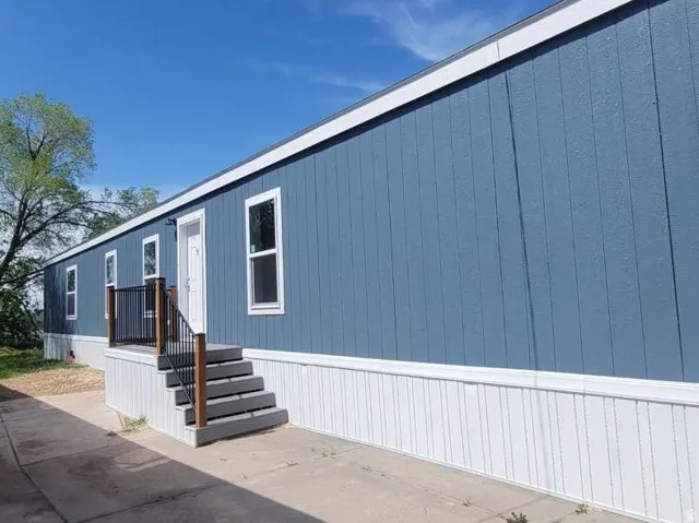 Newly constructed home featuring blue vertical siding with white trim
