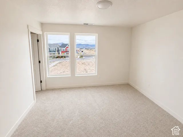 Bright room featuring twin windows, neutral tone carpet, white baseboards, and a contemporary ceiling light fixture