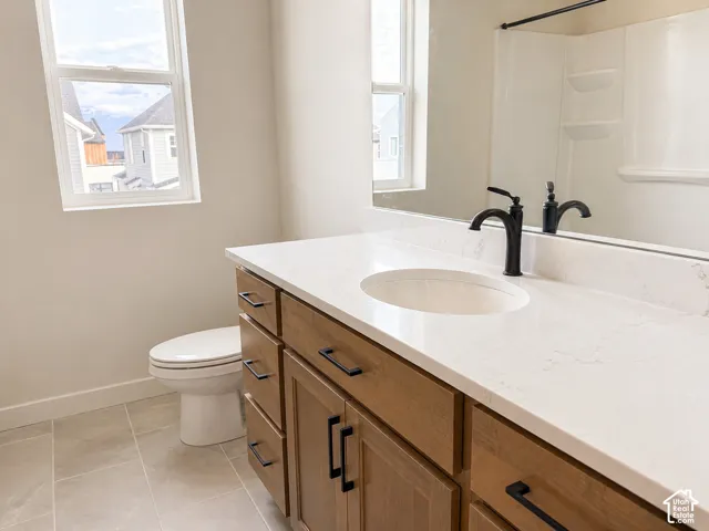 Bathroom vanity featuring a light-toned countertop with an integrated sink and a black-finish faucet