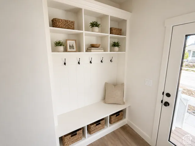 Built-in mudroom bench with cubby storage, upper shelving, and dark hardware
