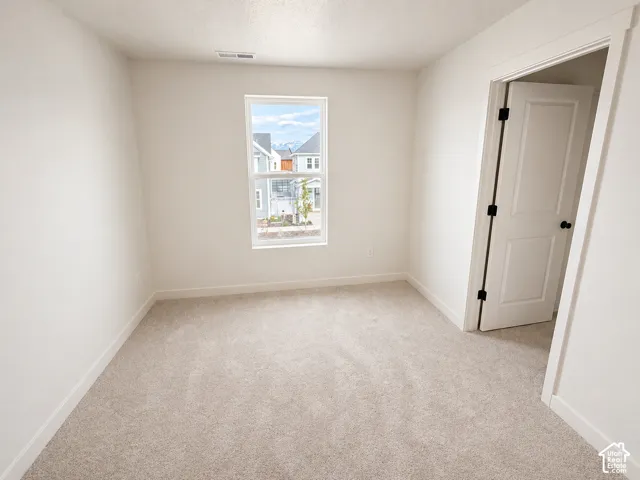 Light-filled interior space featuring neutral tone carpeting and crisp white walls