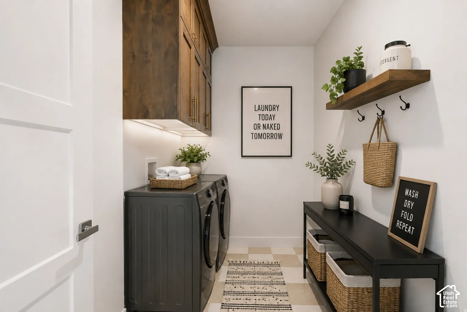 Laundry area featuring dark wood-finish cabinetry with under-cabinet lighting, a pair of dark-finish laundry machines, and patterned floor tiles