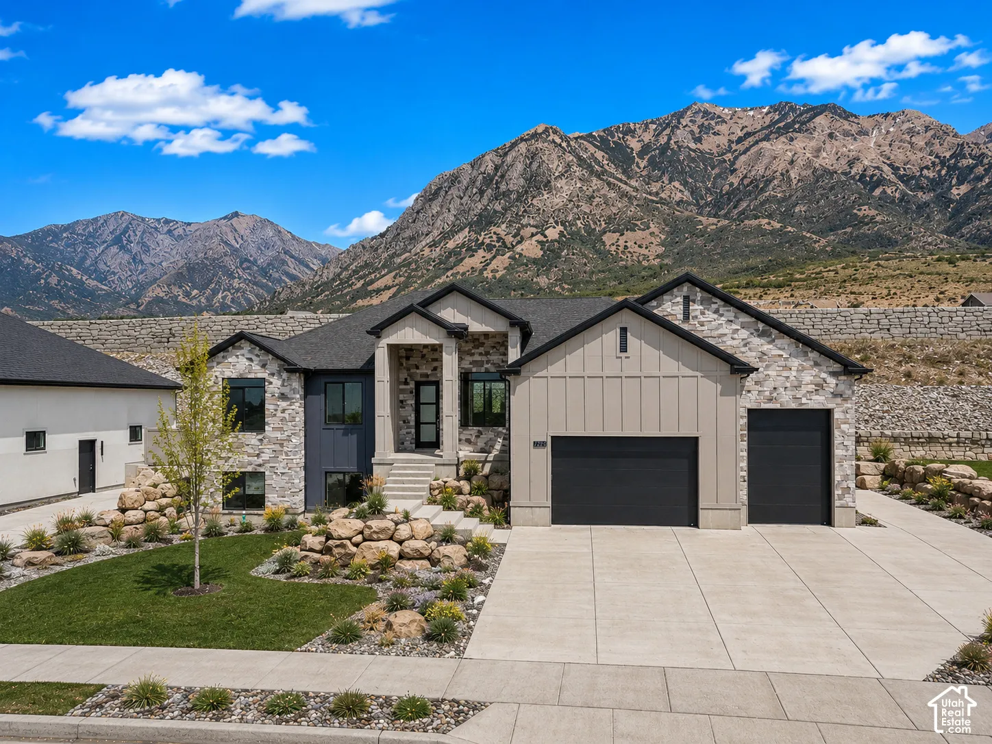 Contemporary stone and siding exterior with a dark shingle roof